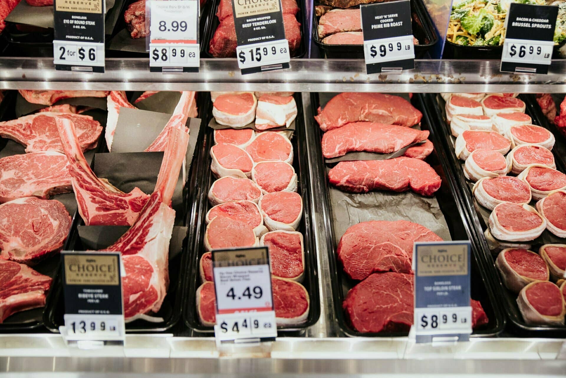 A variety of different meat cuts in a grocery store meat case.