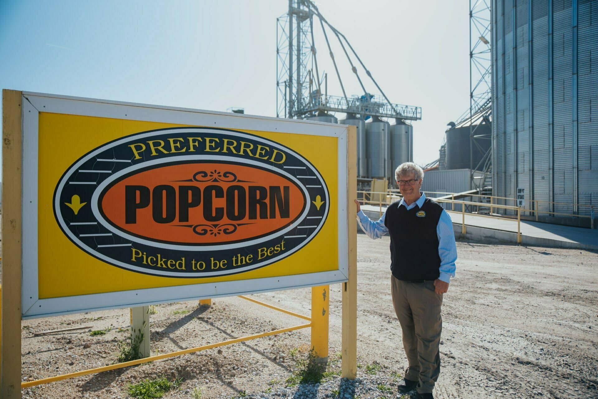 Norm Krug stands next to a sign for Preferred Popcorn.