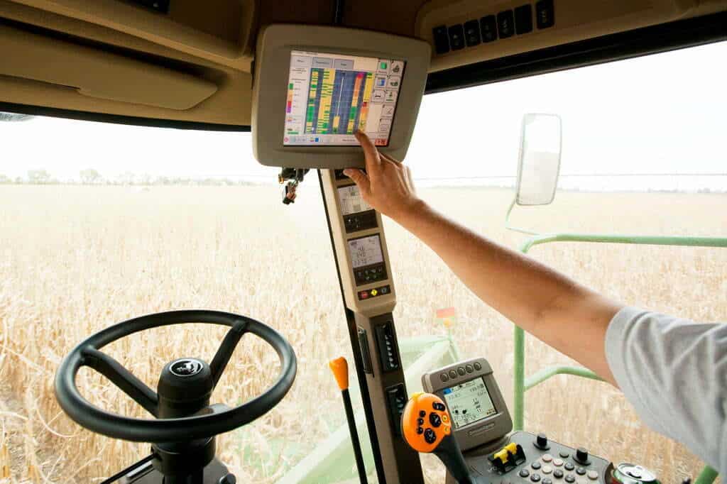Farmer operating the controls of a combine