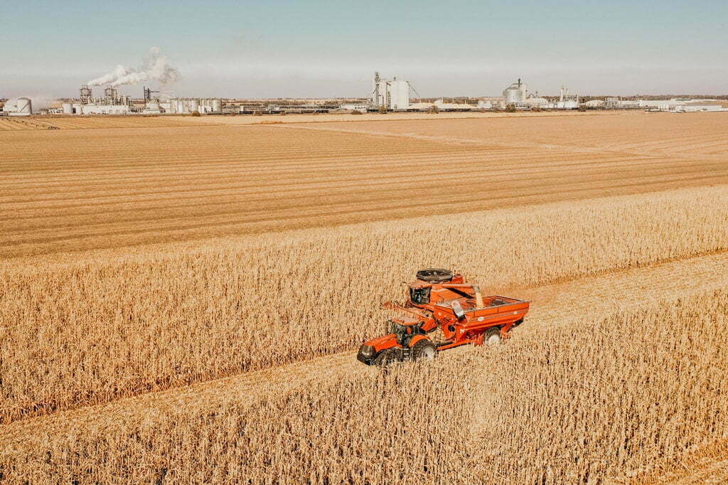 Red combine driving through cord field