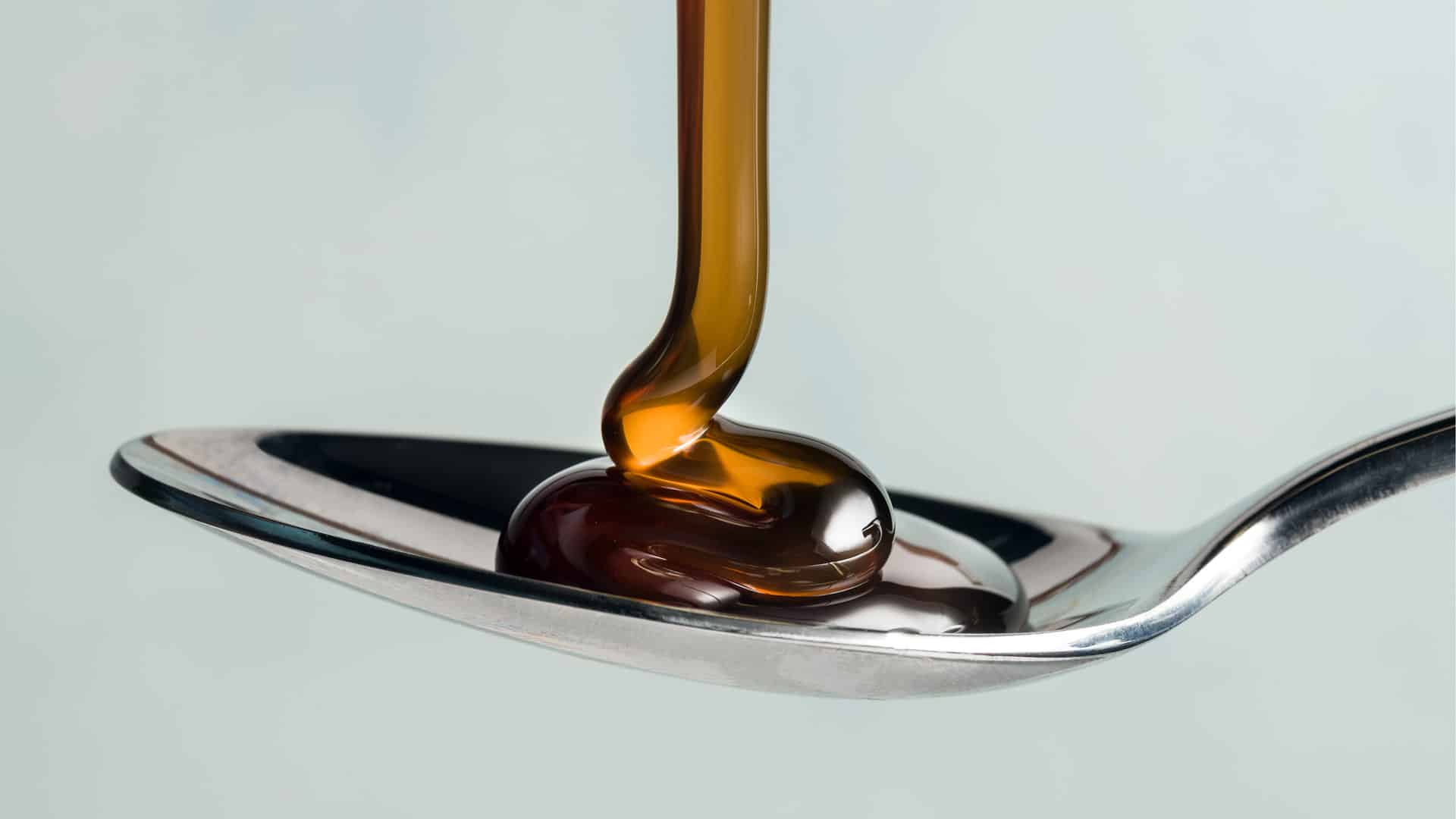 Corn syrup being poured on to a spoon.