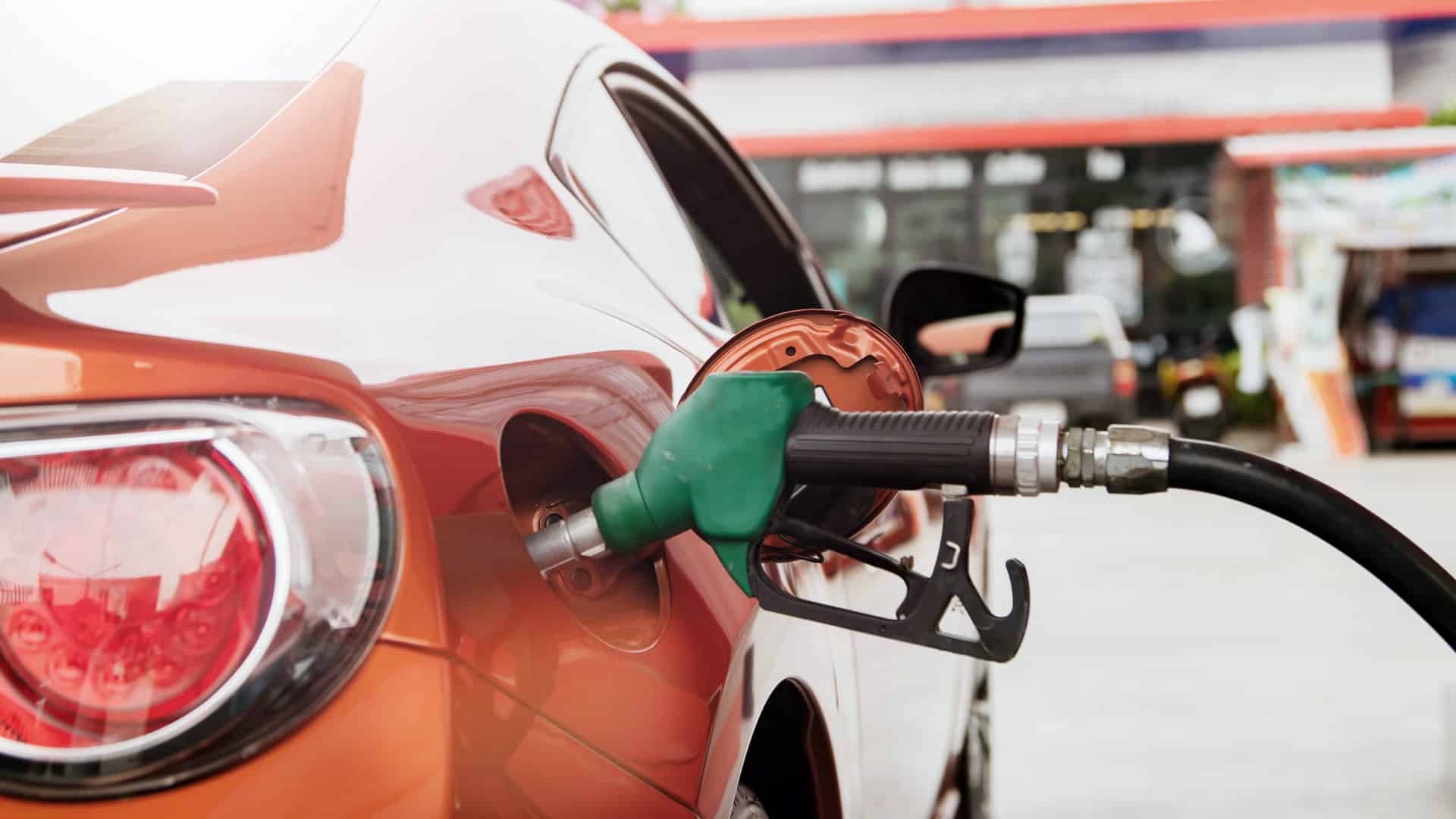A flex fuel gas pump is shown in a red car's gas tank.